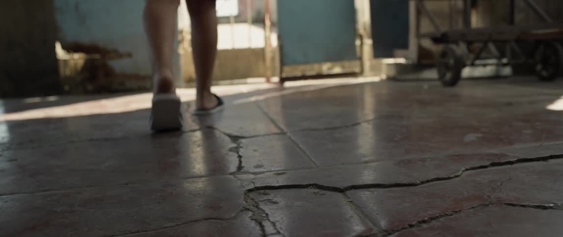 Person walks on cracked concrete