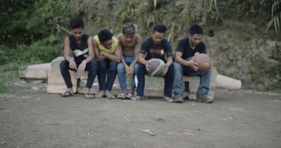 A group of men sit together on rocks
