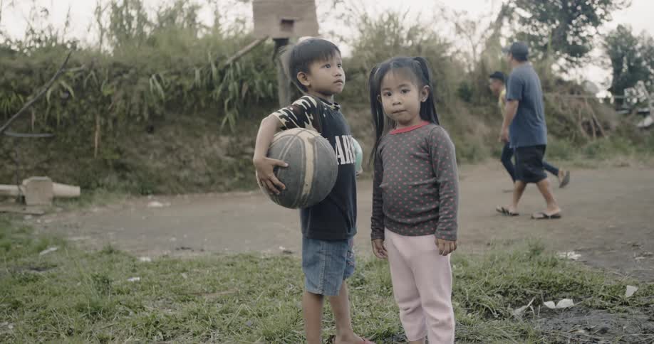 Children watch as men play basketball