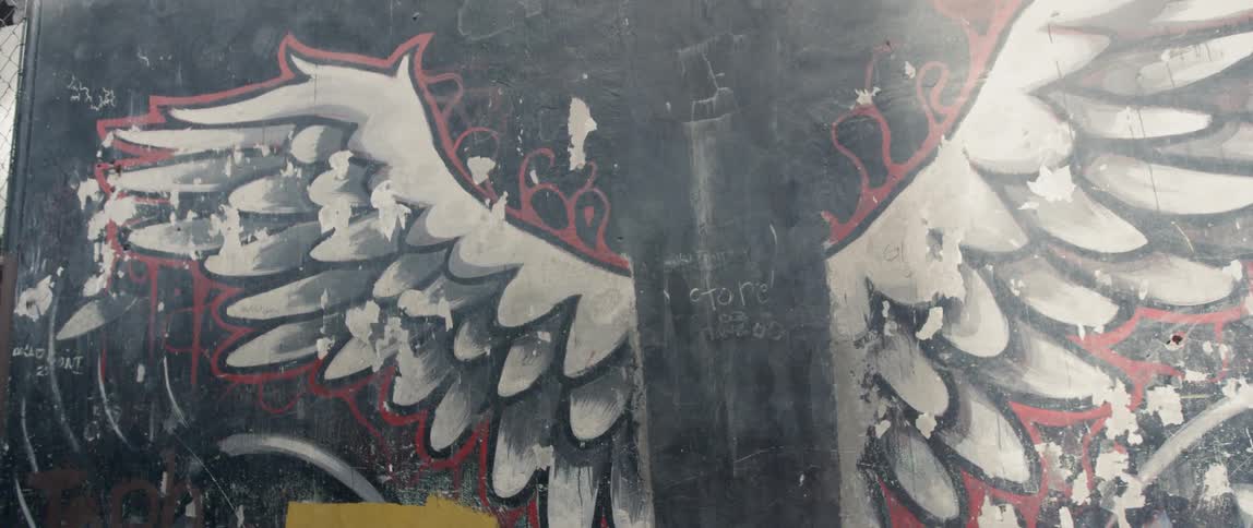 A mural is covering a wall outside a building in daylight