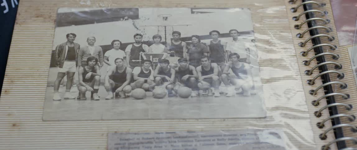 Hand points to a black and white picture of a sports team