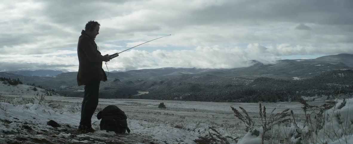 A man is fishing in the ice