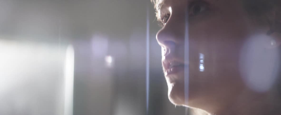 A woman sits up wide awake with an anxious look on her face