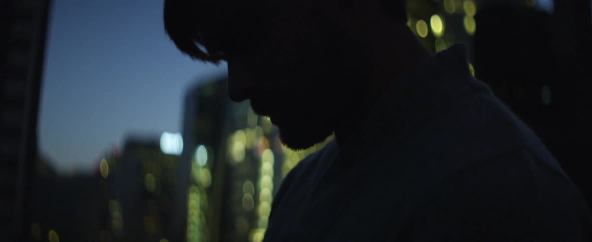 A man smokes in the city at night