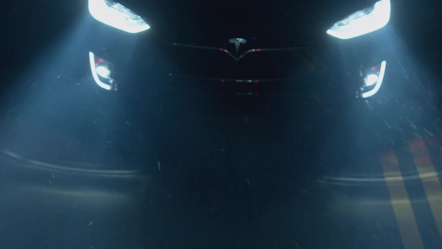 Car headlights shine off the road at night