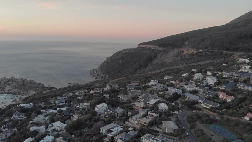 The houses are lined against the shore at sunset