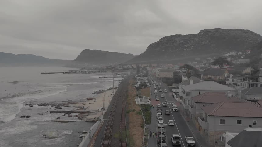 Cars drive on a beachside road