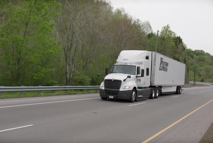 A semi drives on a rural road