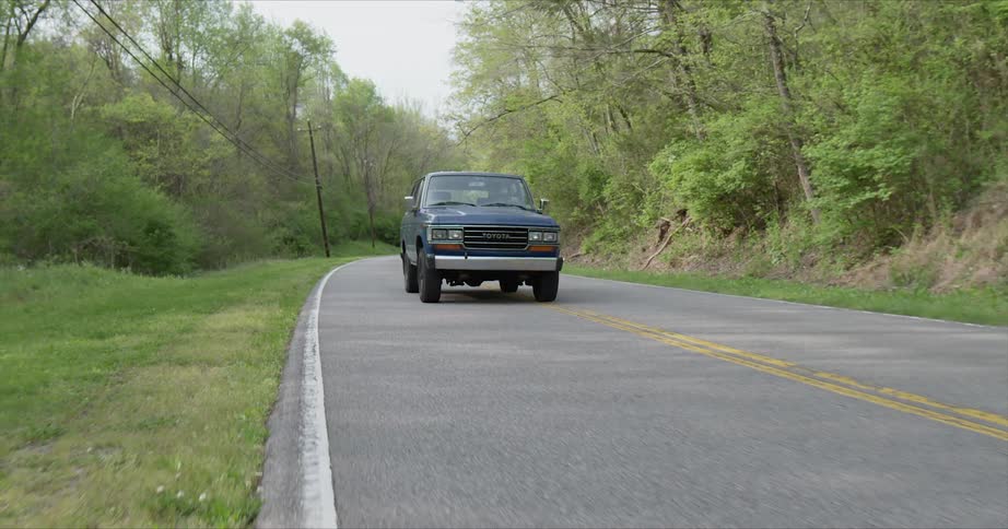 Truck travels along wooded highway