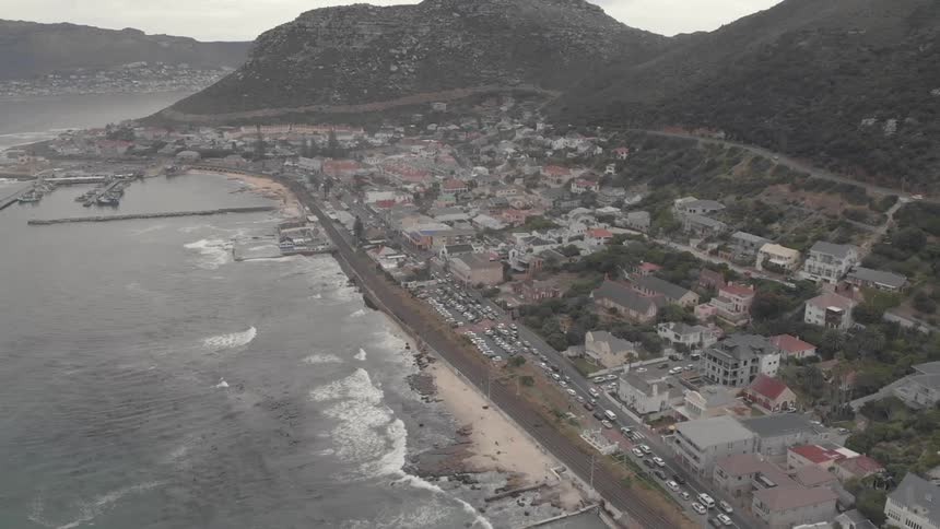 The waves crash against the coastal town shore