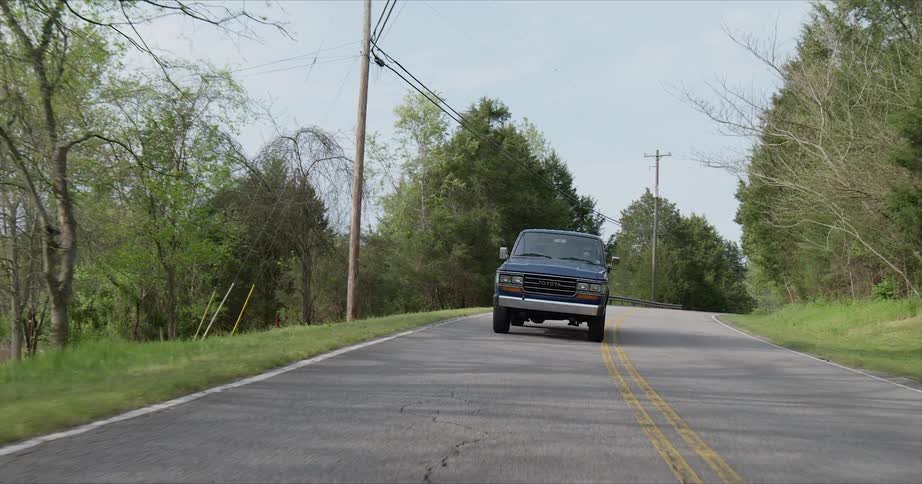 The truck is driving down the long road