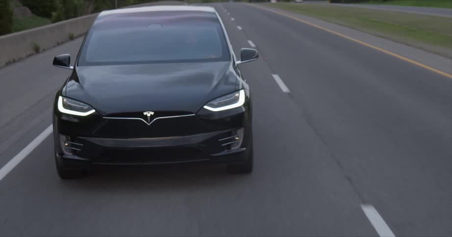 The black car rides down the long road