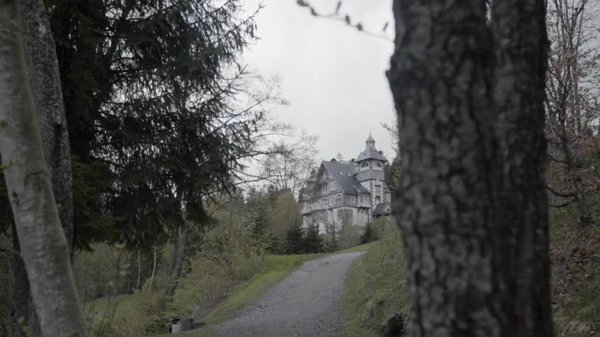 A large mansion sits atop the hill