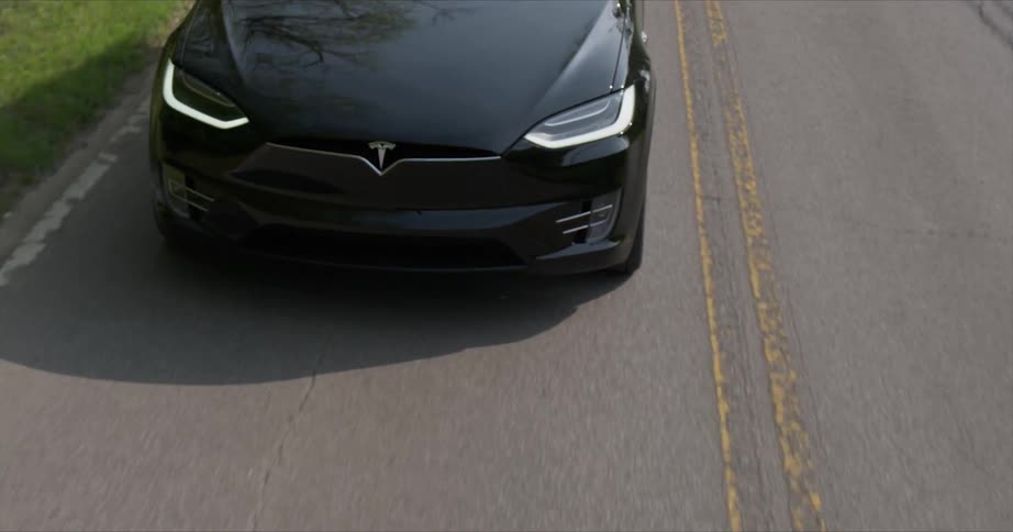 The black car travels on the empty road