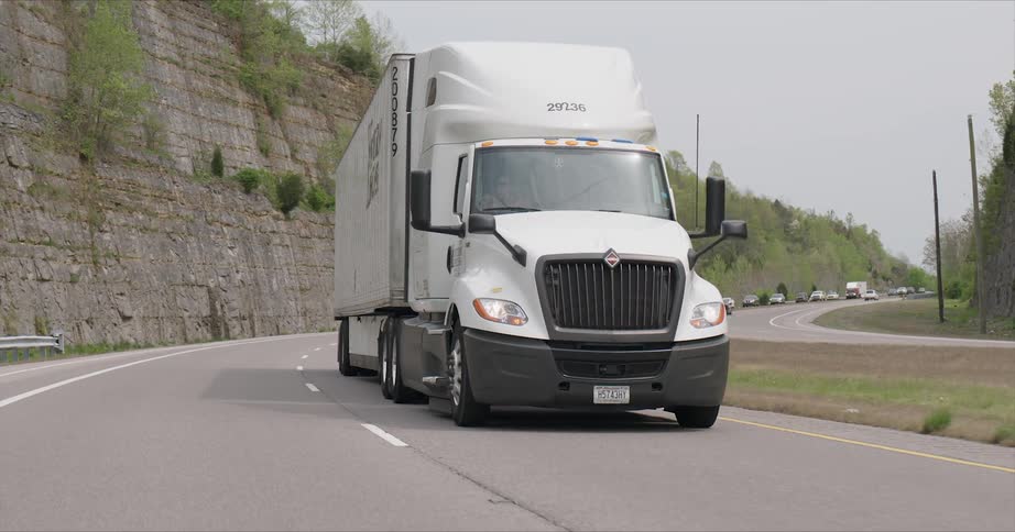A big rig truck rides on the highway road