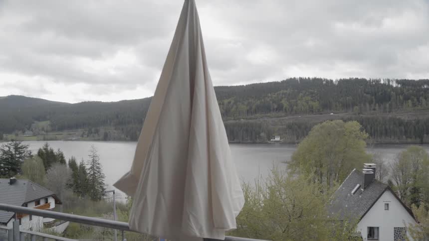 Umbrella on a balcony sways in the wind