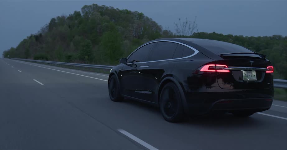 A tesla car rides on the highway road