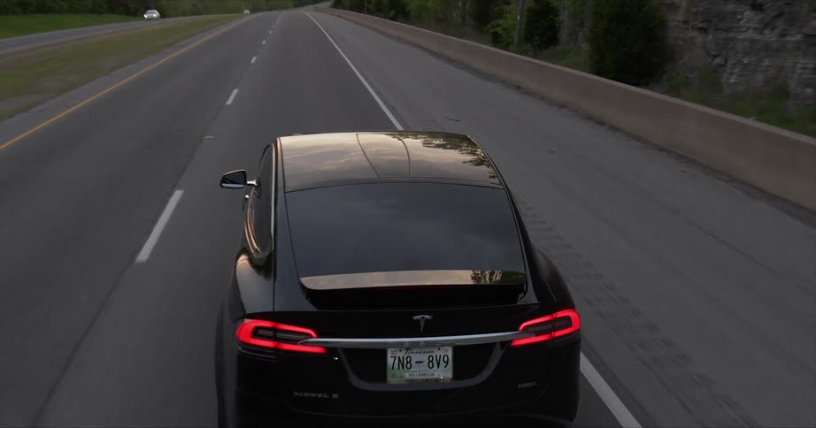 The black car drives past another car on the opposite road