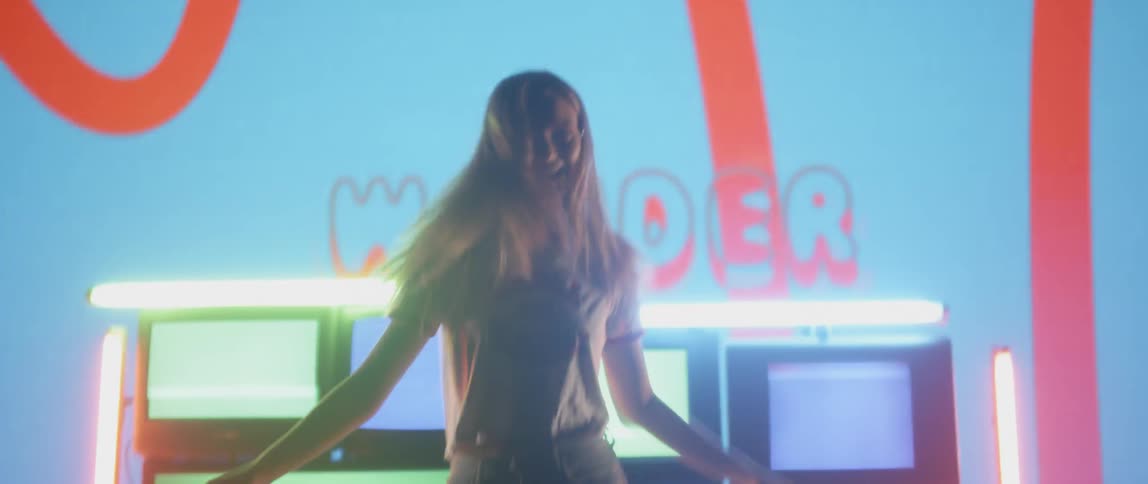 A girl dances in front of the flashing lights