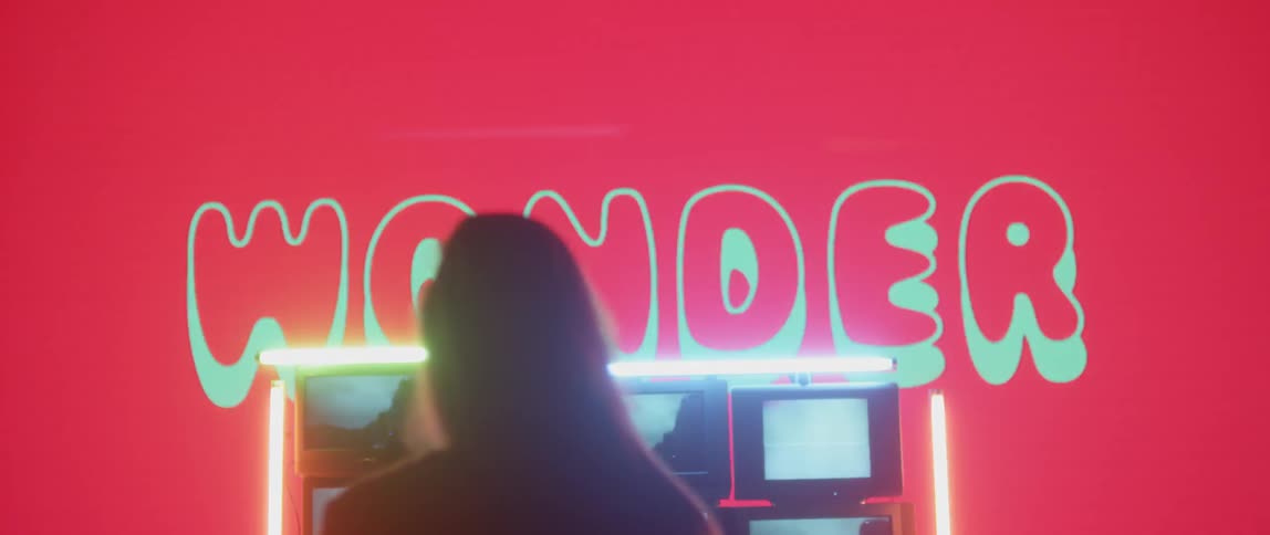 Woman stands in front of flashing screens