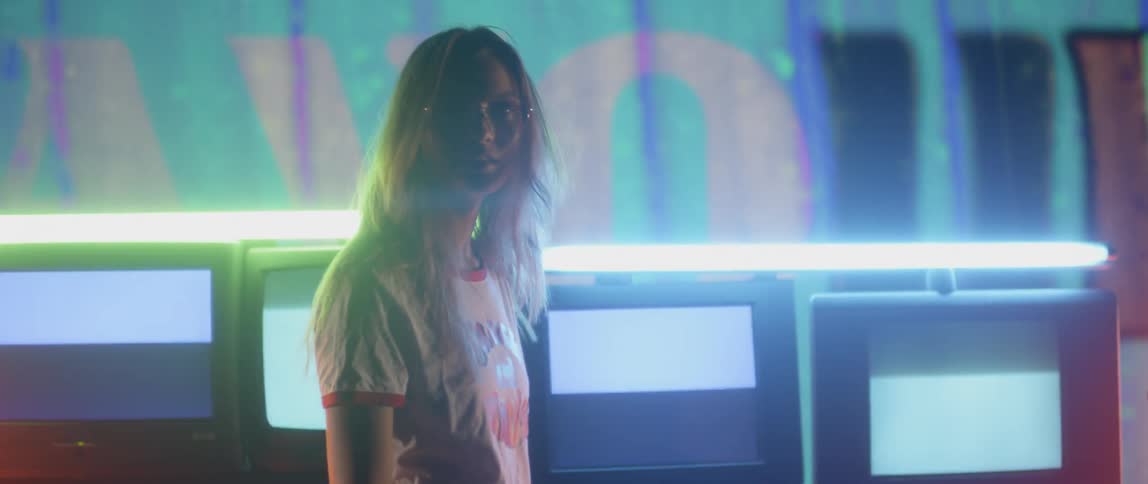 Woman standing in front of neon lights turns around