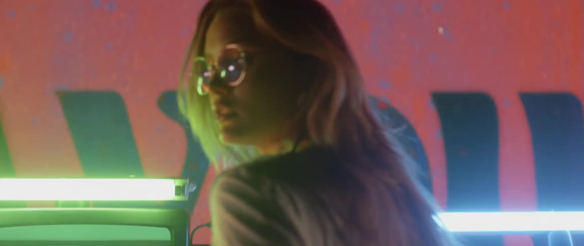 The woman turns around in front of the large screen