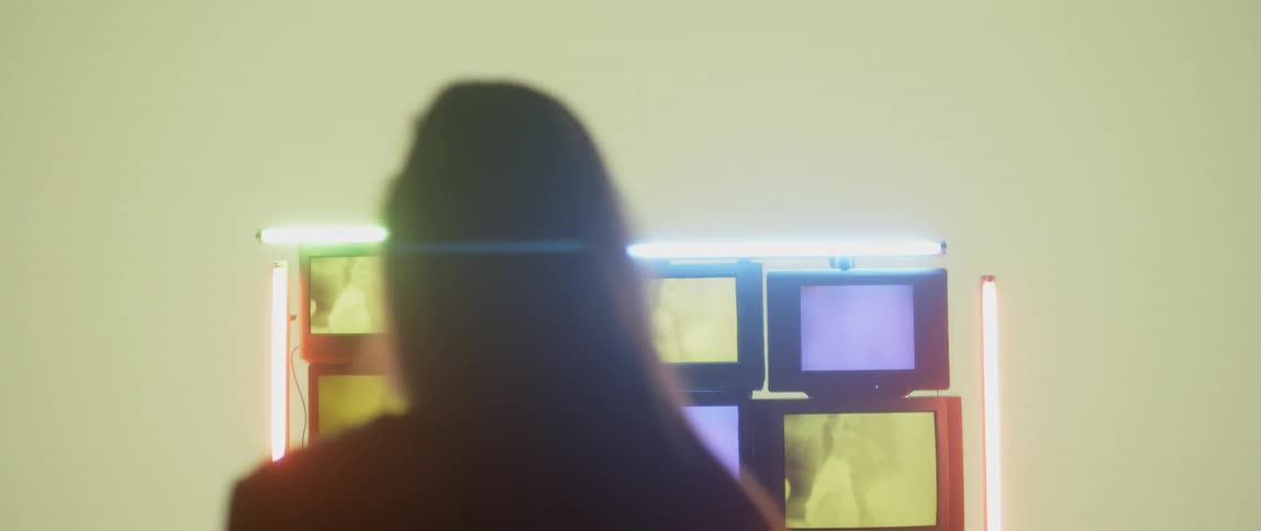 A woman is looking at an installation of monitors displaying images