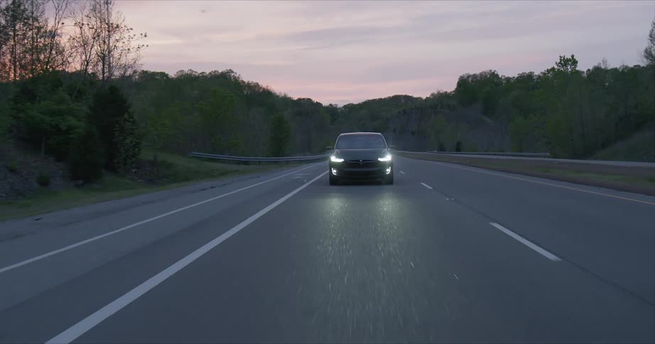 Car is driven on a rural road at sunset