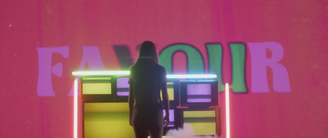 The woman walks up to the stack of televisions