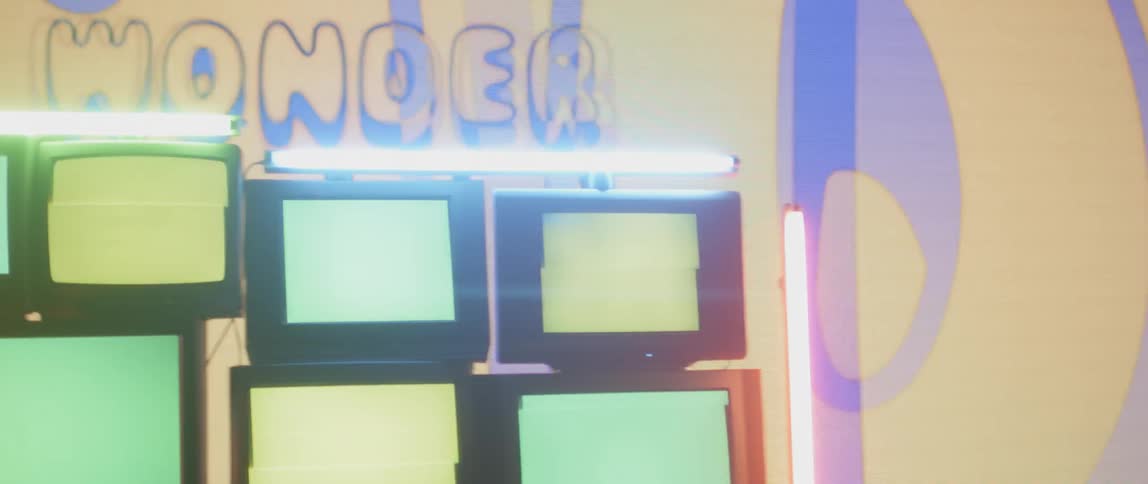 A stack of televisions stand in front of a projector screen