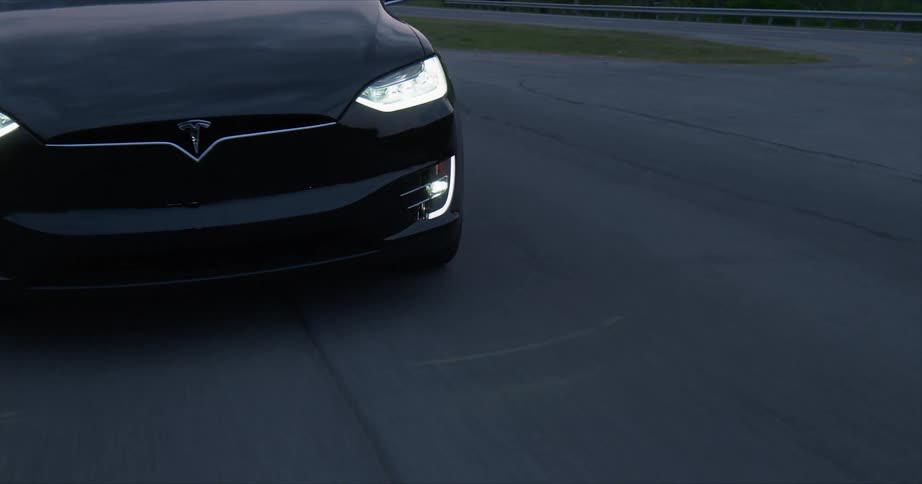 Car drives on a rural road at sunset