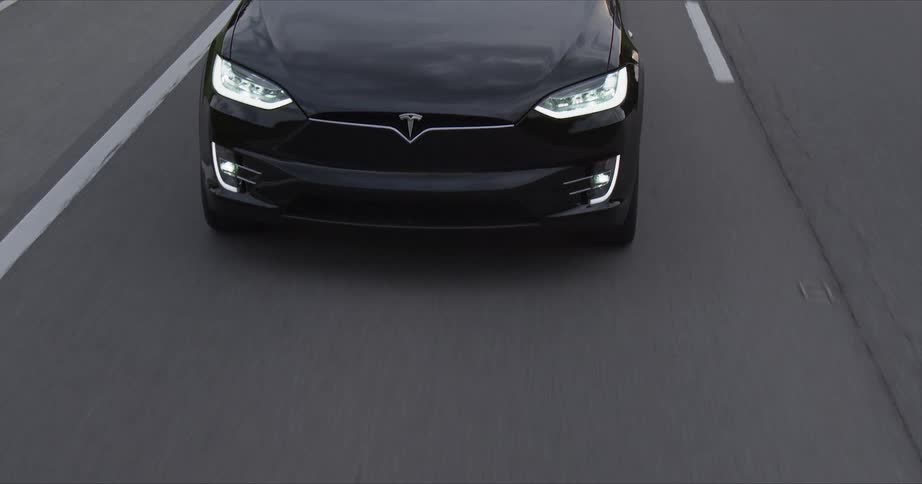 Black vehicle travels down a highway