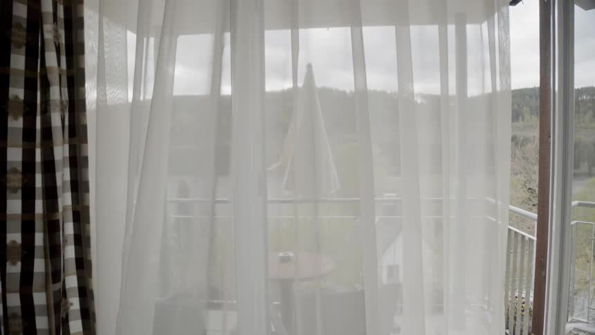 White curtains blow in a gentle breeze