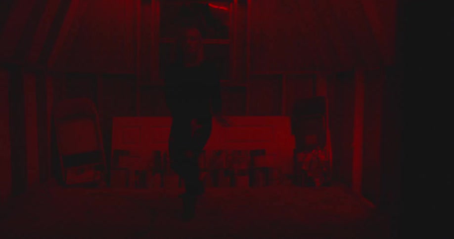 Woman dances in a dark shed