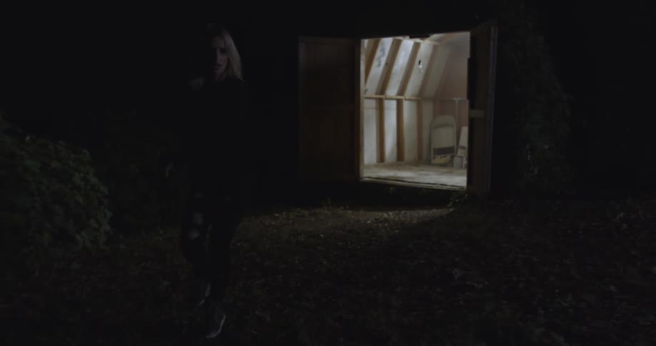 A woman runs out of the barn dancing