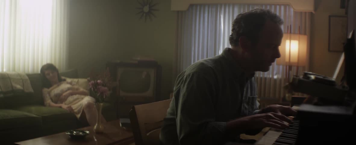 A man plays the piano in a living room