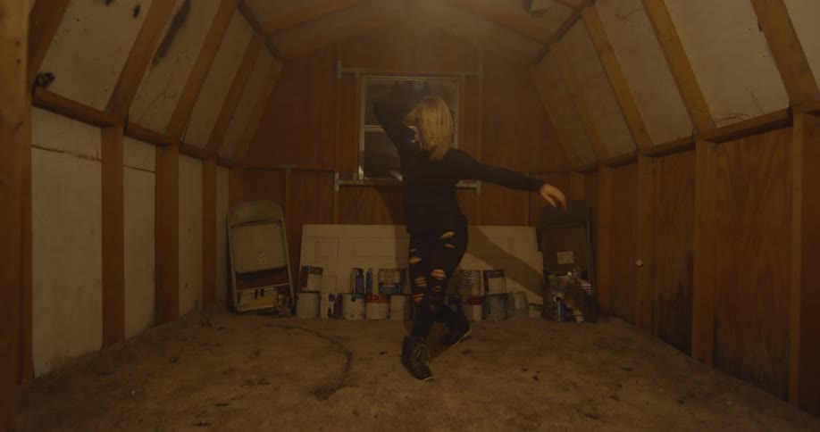 A woman dances in a small room