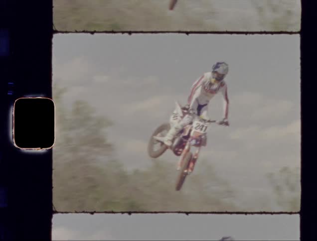 A young man performs a jump on a dirt bike