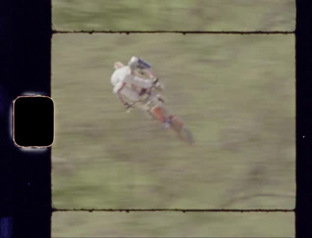 A dirt bike rider lands a long jump