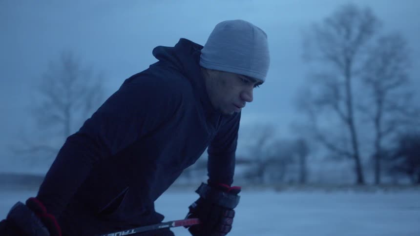 A man skates around on the ice with a hockey stick