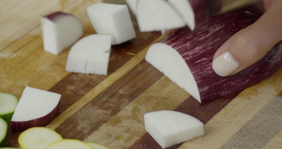 Woman is chopping vegetables on cutting board