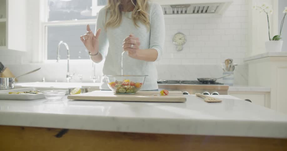 A woman mixes food together in a bowl