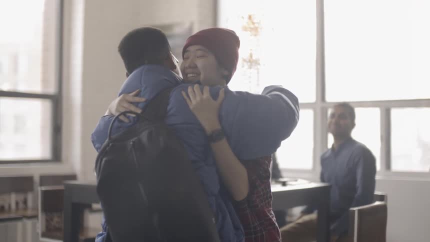A man walks in the room and is given a hug