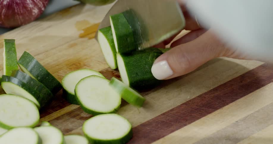 Person slices vegetables on a cutting board