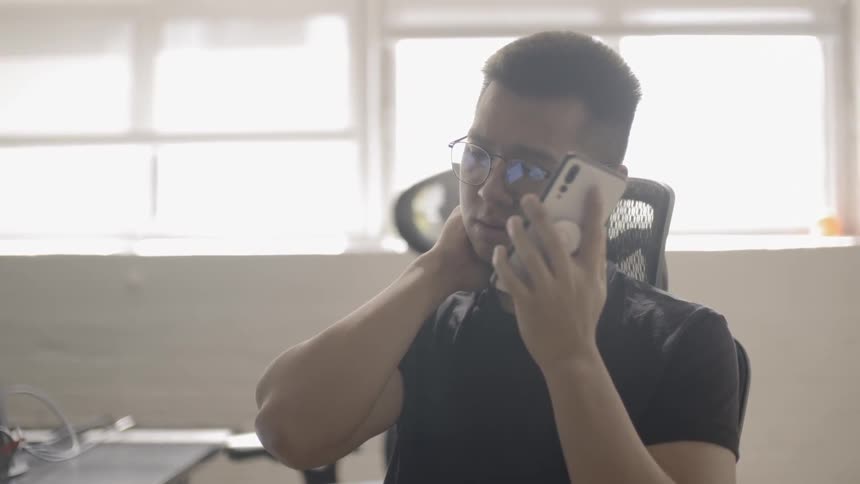 A man uses his phone inside an office
