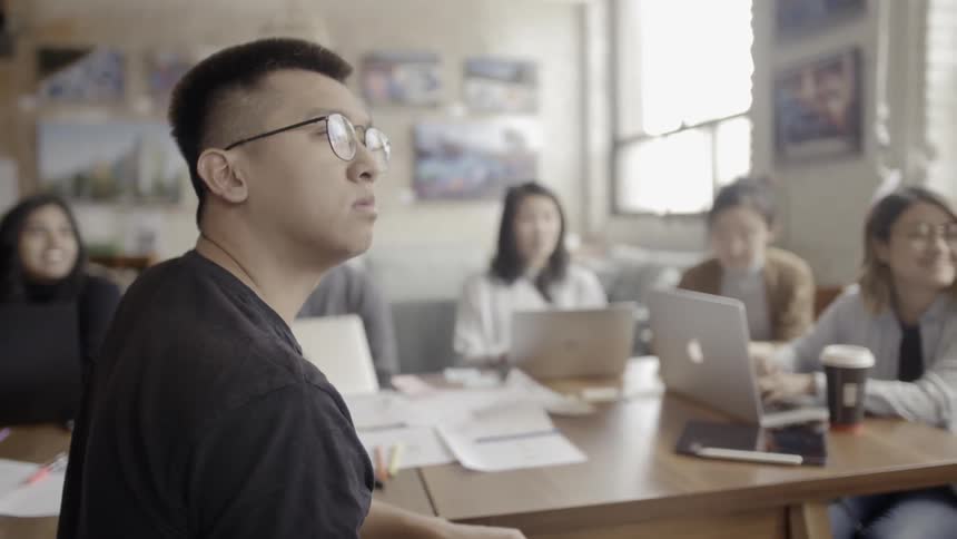 Employees sit around a conference table