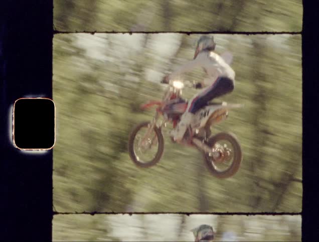 The person jumps high on the dirt bike
