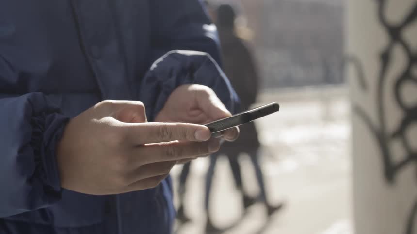 A person uses a cell phone outside