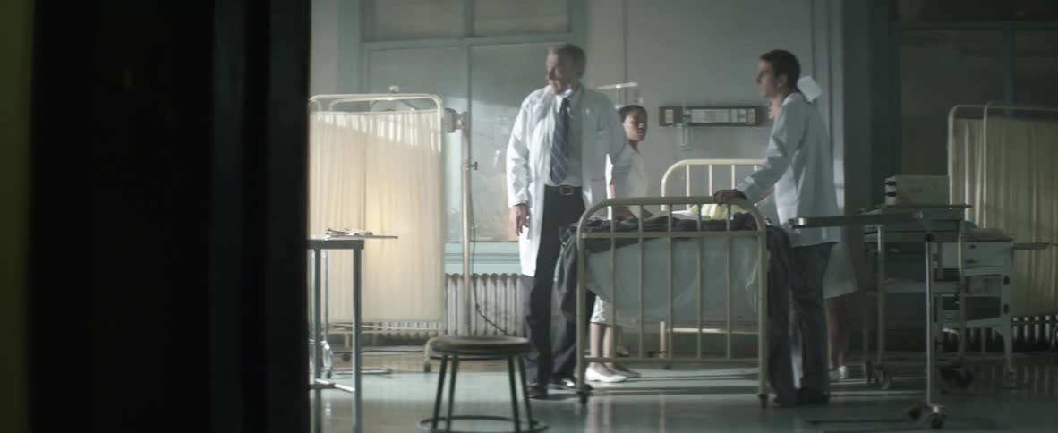 Doctors near a gurney distracted by a light from the window