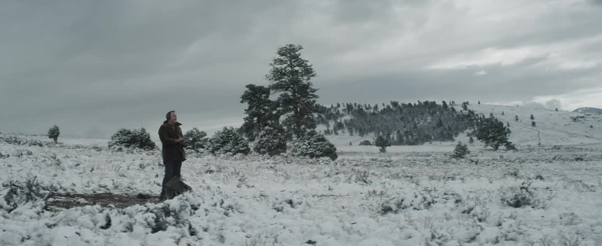 A man stands in a snowy field
